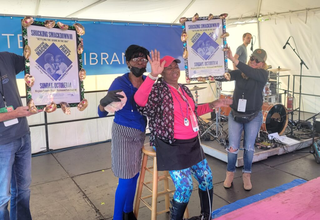 Clementine Macon Boyd and Deborah Pratt celebrate their oyster shucking contest on the Center for Cultural Vibrancy Virginia Folklife Stage on October 9, 2022. 