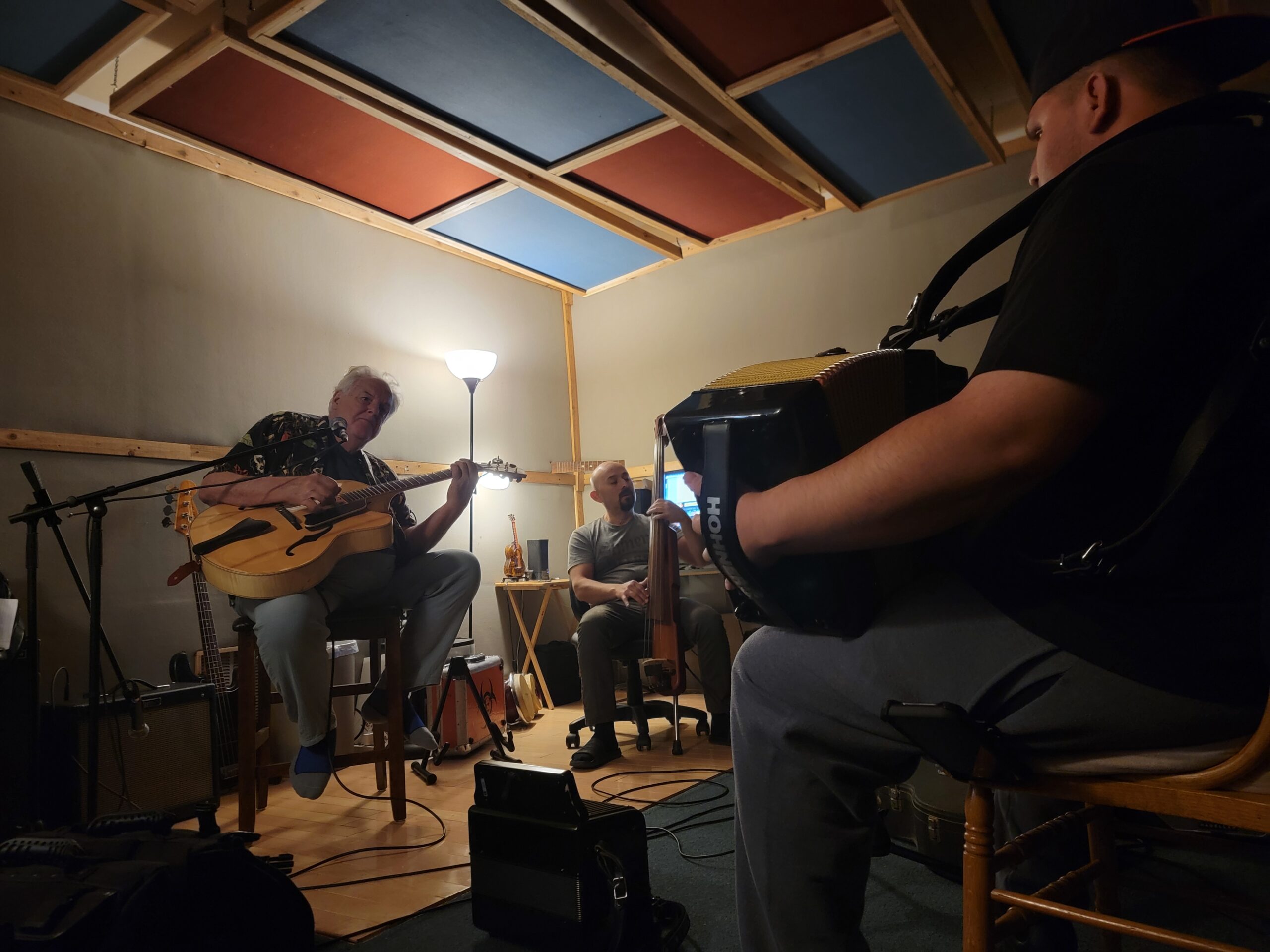 Peter Rowan plays guitar while Josh Baca plays accordion during a recording session.