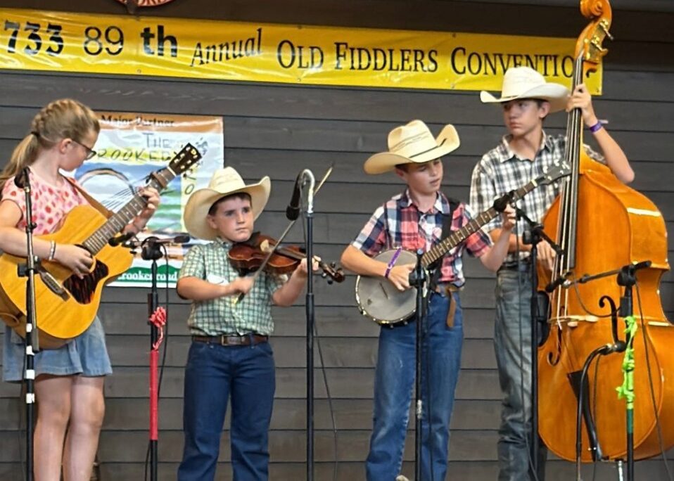 4 kids play instruments at the 2025 Galax Old Fiddlers Convention