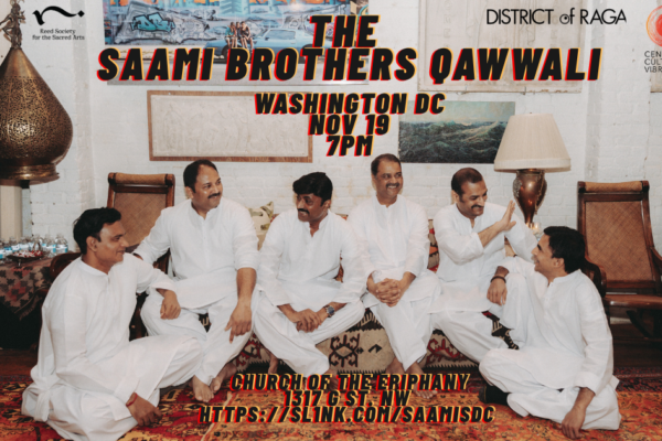 6 men in white clothes sit on the floor on a multi-colored rug